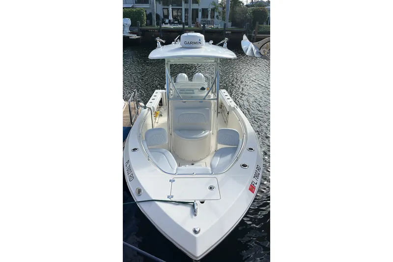 The Image of 2016 Cobia 237 Center Console boat docked on calm water. - 3