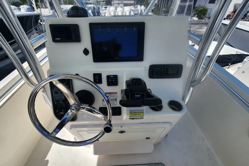 Slide: The Image of 2016 Cobia 237 Center Console boat dashboard with steering wheel and navigation controls. - 4