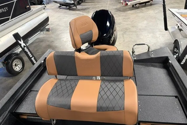Slide: The Image of 2027 Xpress H20 Bay boat with stylish tan and gray seating in a showroom. - 15