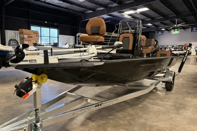 The Image of 2027 Xpress H20 Bay boat on trailer in showroom, featuring Minn Kota trolling motor. - 1