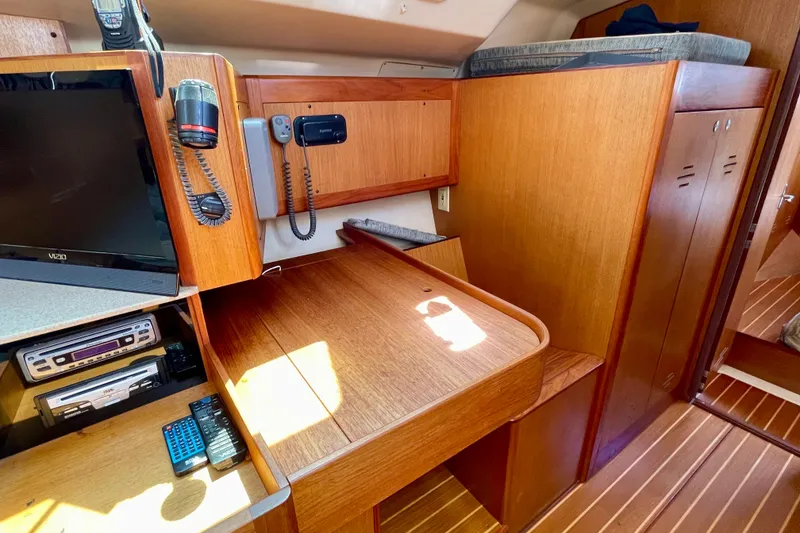 Slide: The Image of Interior of 1999 Hunter Passage 420 yacht with wooden cabinetry and communication equipment. - 33