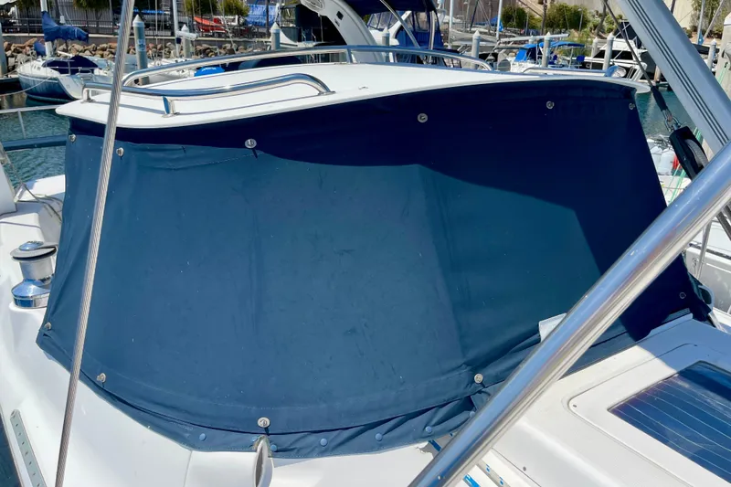 Slide: The Image of 1999 Hunter Passage 420 sailboat with blue canvas cover in marina. - 11