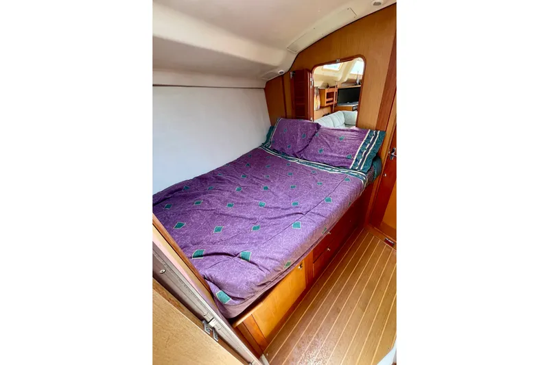 Slide: The Image of Cozy cabin interior of 1999 Hunter Passage 420 sailboat with purple bedding. - 45
