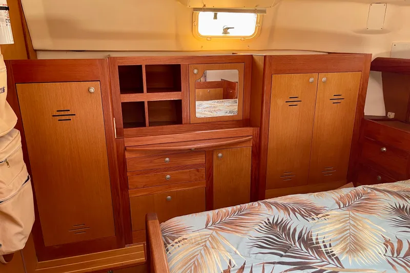 Slide: The Image of Interior of 1999 Hunter Passage 420 yacht with wooden cabinetry and tropical bedding. - 41