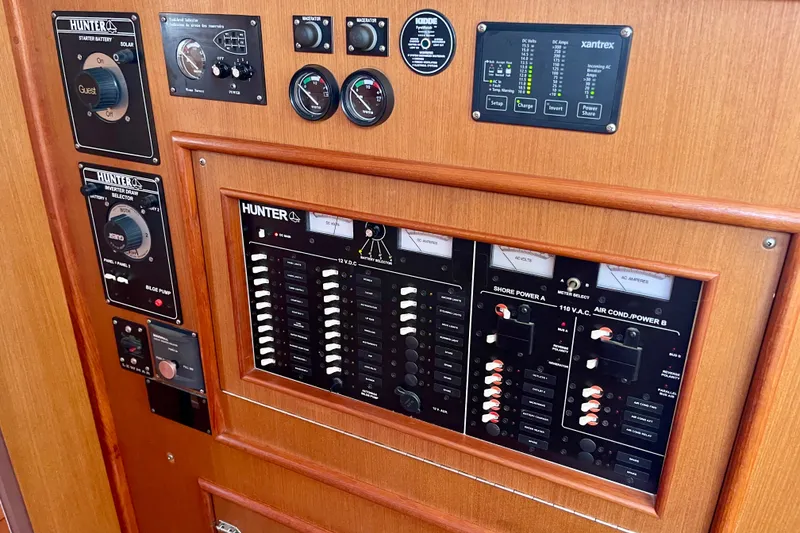 Slide: The Image of Control panel of a 1999 Hunter Passage 420 sailboat, featuring various switches and gauges. - 38