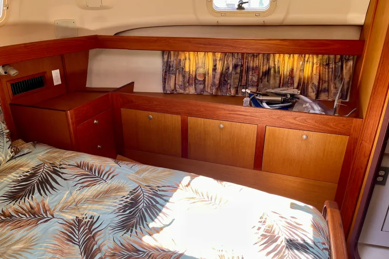 Slide: The Image of Interior of 1999 Hunter Passage 420 yacht with wood cabinetry and tropical bedding. - 42