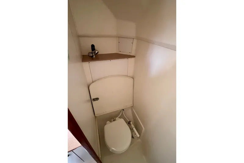 Slide: The Image of Compact bathroom in 1999 Hunter Passage 420 sailboat, featuring a toilet and shelf. - 44
