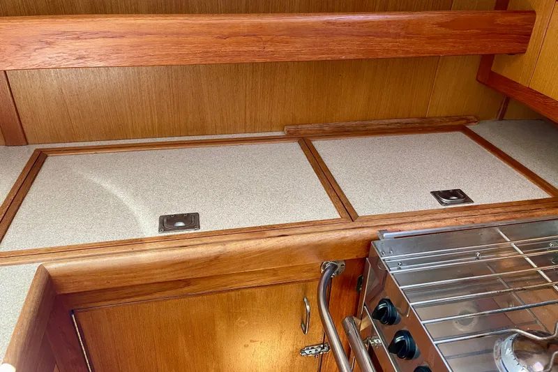 Slide: The Image of Interior of 1999 Hunter Passage 420 yacht kitchen with wooden cabinetry and stove. - 28