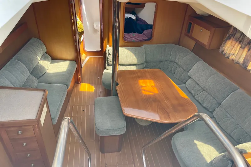 Slide: The Image of Interior of 1999 Hunter Passage 420 yacht with cozy seating and wooden table. - 23