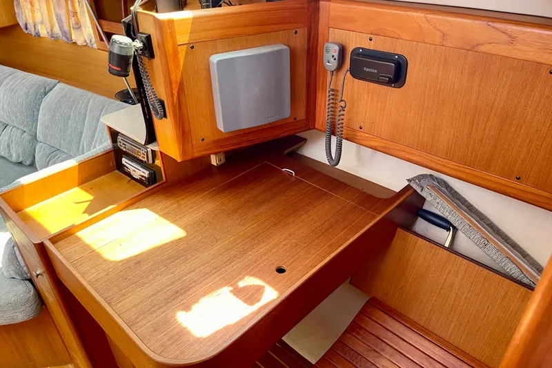 Slide: The Image of 1999 Hunter Passage 420 yacht interior with wooden navigation desk and communication equipment. - 35