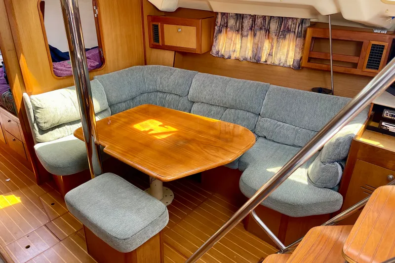 Slide: The Image of Cozy interior of 1999 Hunter Passage 420 sailboat with wooden table and cushioned seating. - 31