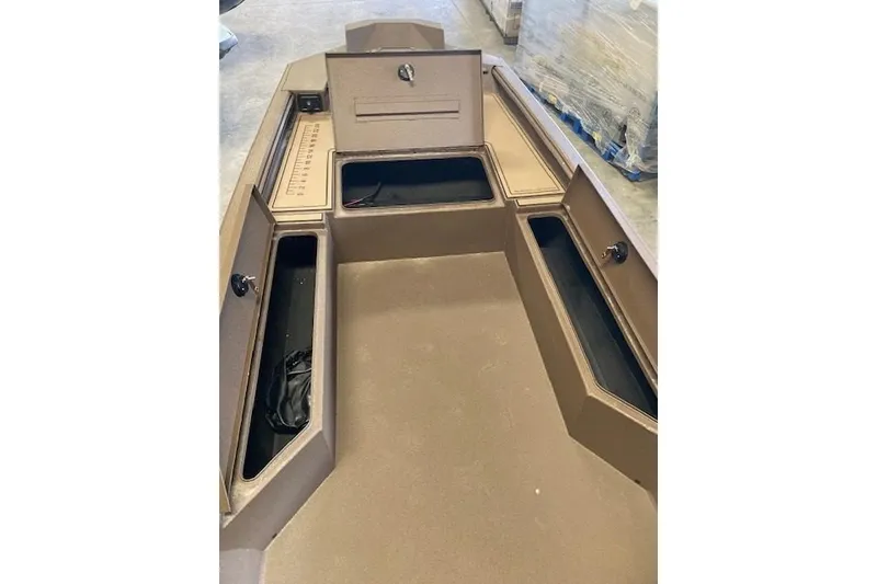 Slide: The Image of 2026 Xpress Bayou 180CC boat interior with storage compartments and measuring board. - 6