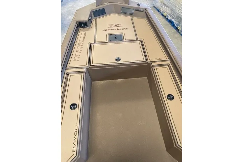 Slide: The Image of 2026 Xpress Bayou 180CC boat interior with tan deck and storage compartments. - 5