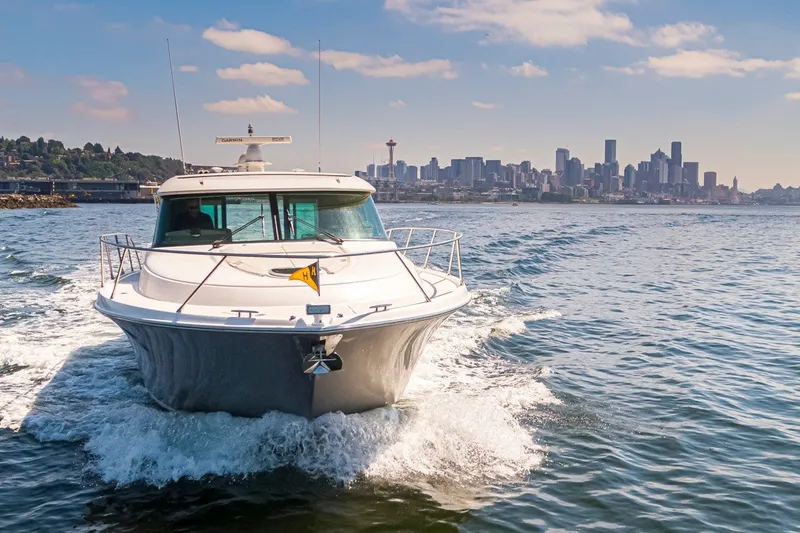 Slide: The Image of 2019 Tiara Yachts C44 Coupe cruising with city skyline in the background. - 54