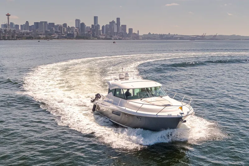 Slide: The Image of 2019 Tiara Yachts C44 Coupe cruising with city skyline in the background. - 50