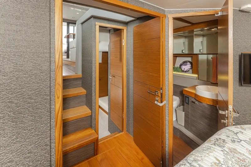 Slide: The Image of Interior of 2019 Tiara Yachts C44 Coupe, featuring wooden stairs and modern bathroom. - 17