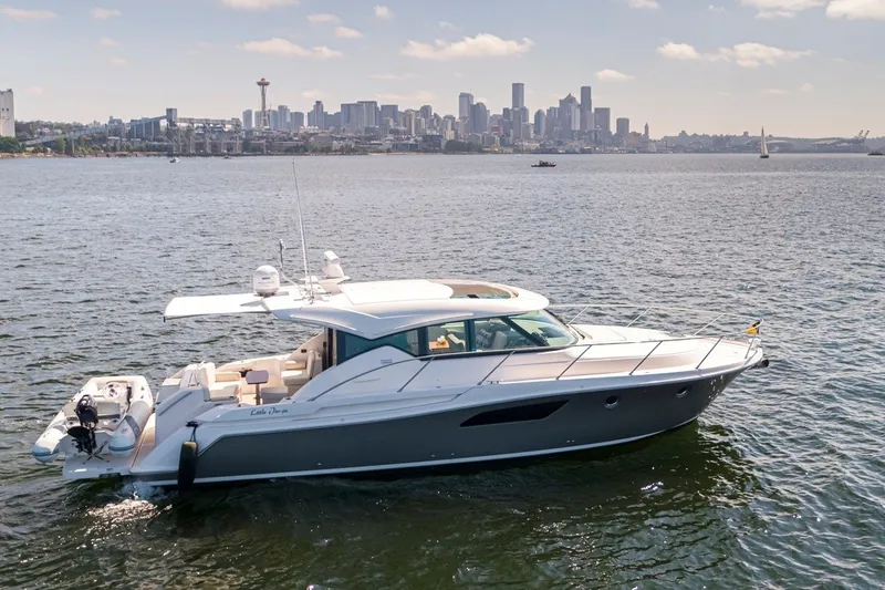 Slide: The Image of 2019 Tiara Yachts C44 Coupe cruising on water with city skyline backdrop. - 36