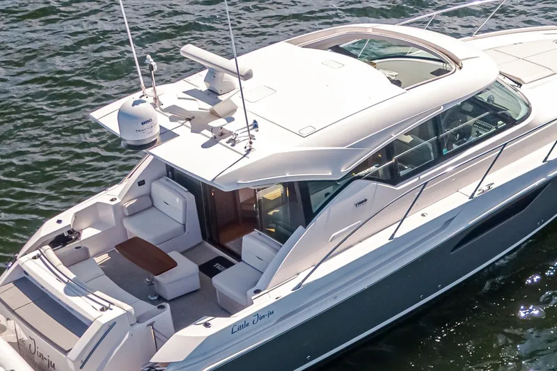 Slide: The Image of 2019 Tiara Yachts C44 Coupe cruising on water, showcasing sleek design and spacious deck. - 40