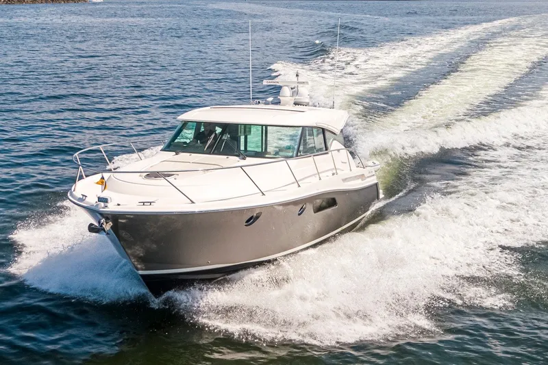 The Image of 2019 Tiara Yachts C44 Coupe cruising on open water, creating a dynamic wake. - 0