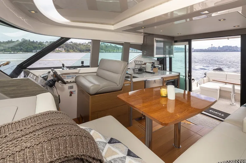 Slide: The Image of Interior of 2019 Tiara Yachts C44 Coupe, featuring luxurious seating and a scenic waterfront view. - 13