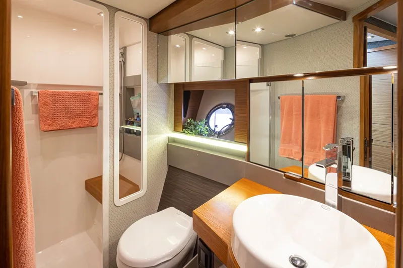 Slide: The Image of Luxurious bathroom interior of 2019 Tiara Yachts C44 Coupe with modern fixtures and orange towels. - 19