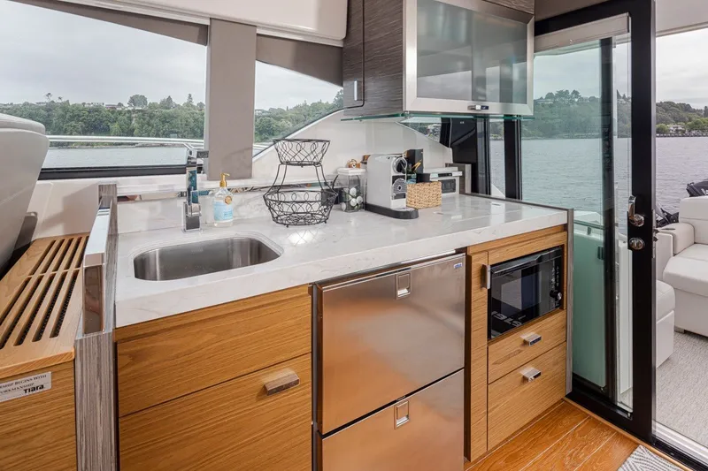 Slide: The Image of Modern kitchen interior of 2019 Tiara Yachts C44 Coupe with sleek appliances and lake view. - 9
