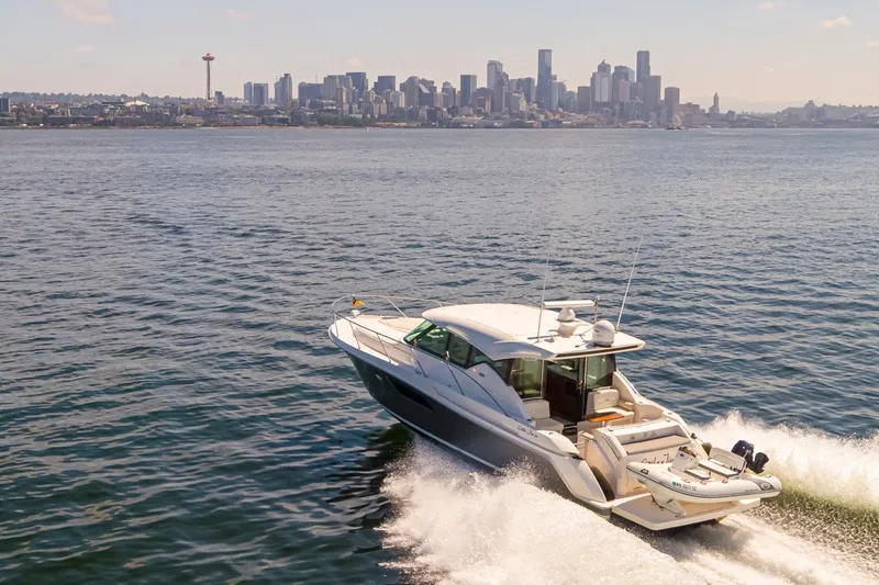 Slide: The Image of 2019 Tiara Yachts C44 Coupe cruising near city skyline on sunny day. - 48
