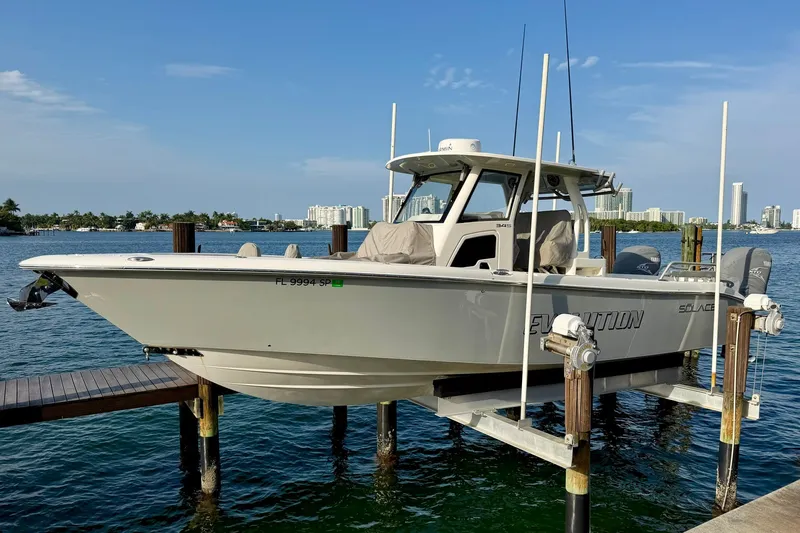 The Image of 2020 Solace 345CC boat docked on a lift in a marina setting. - 1