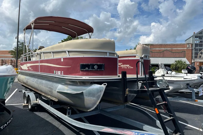 Slide: The Image of 2014 Bentley Pontoons Elite 250 on trailer, parked outdoors under cloudy sky. - 1