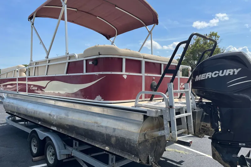 Slide: The Image of 2014 Bentley Pontoons Elite 250 with Mercury engine on trailer, featuring red and beige design. - 2
