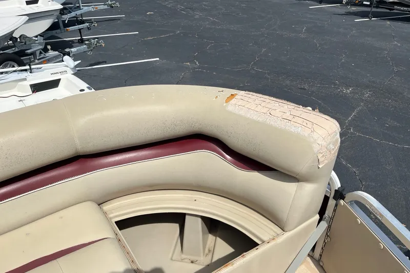 Slide: The Image of 2014 Bentley Pontoons Elite 250 with worn beige and maroon seating in a parking lot. - 9