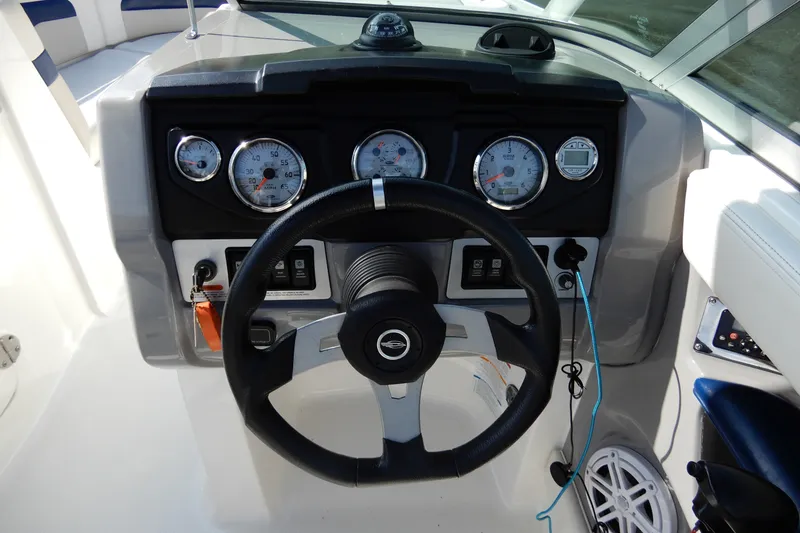 Slide: The Image of 2017 Chaparral 246 SSi boat dashboard with steering wheel and gauges. - 23