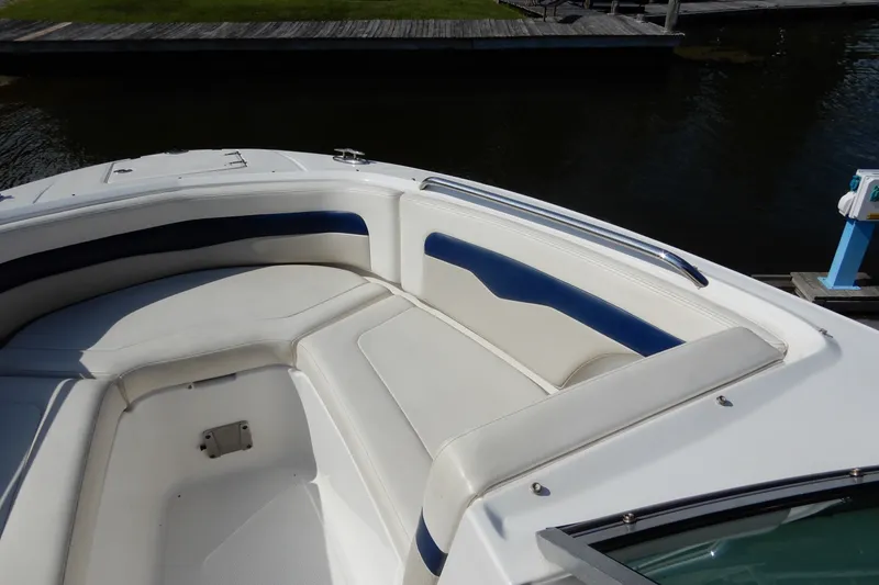 Slide: The Image of 2017 Chaparral 246 SSi boat interior with white and blue seating, dockside view. - 27