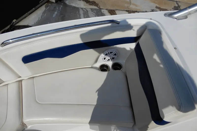Slide: The Image of 2017 Chaparral 246 SSi boat interior with white and blue seating, cup holders, and speaker. - 29