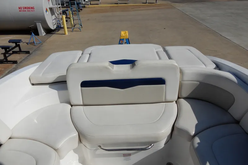 Slide: The Image of 2017 Chaparral 246 SSi boat interior with white cushioned seating and storage area. - 13
