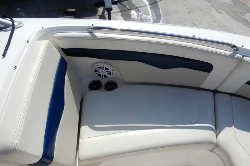 Slide: The Image of 2017 Chaparral 246 SSi boat interior with white and blue seating, cup holders, and speaker. - 28