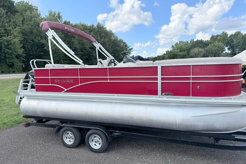 The Image of 2016 Sylvan Mirage 8520 pontoon boat on trailer, red exterior, parked outdoors. - 0