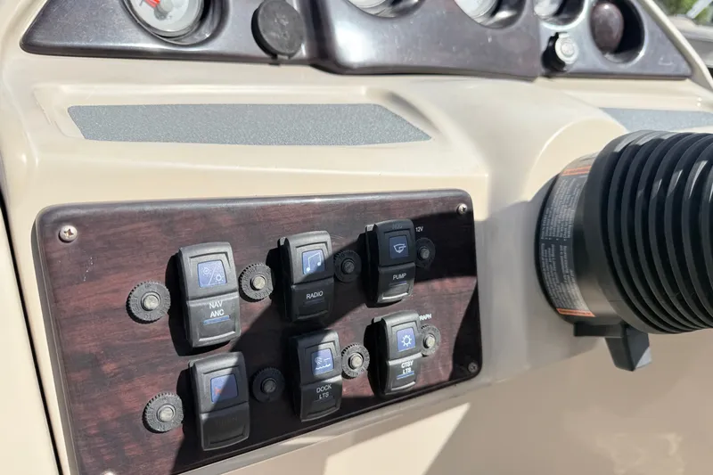 Slide: The Image of Dashboard controls of a 2016 Sylvan Mirage 8520 boat, featuring various switches and gauges. - 13