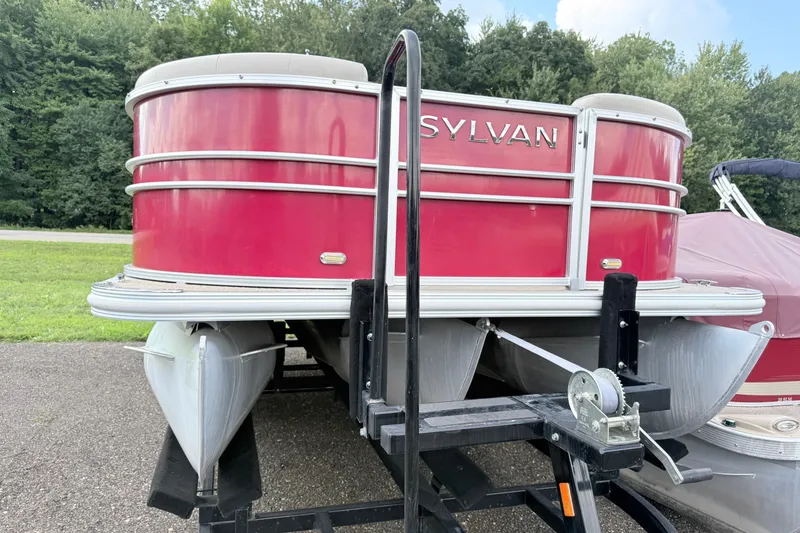 Slide: The Image of 2016 Sylvan Mirage 8520 pontoon boat on trailer, red exterior, parked outdoors. - 4