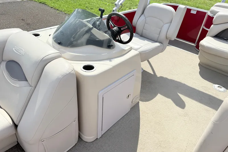 Slide: The Image of Interior of a 2016 Sylvan Mirage 8520 pontoon boat with beige seating and steering console. - 9
