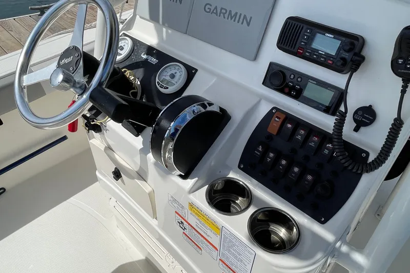 Slide: The Image of 2023 Mako 214 Center Console boat dashboard with steering wheel and navigation controls. - 30