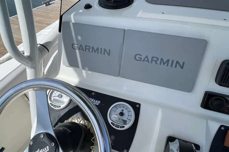 Slide: The Image of 2023 Mako 214 Center Console boat dashboard with Garmin displays and steering wheel. - 27