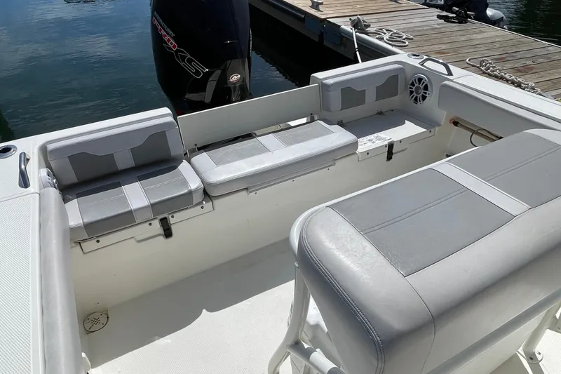 Slide: The Image of 2023 Mako 214 Center Console boat interior with gray seating and docked at marina. - 31