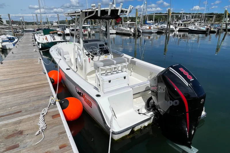 Slide: The Image of 2023 Mako 214 Center Console boat docked at marina with outboard motor. - 14