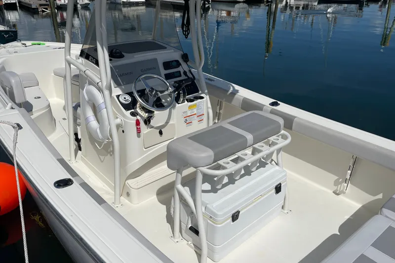 Slide: The Image of 2023 Mako 214 Center Console boat with modern helm and seating, docked at marina. - 18