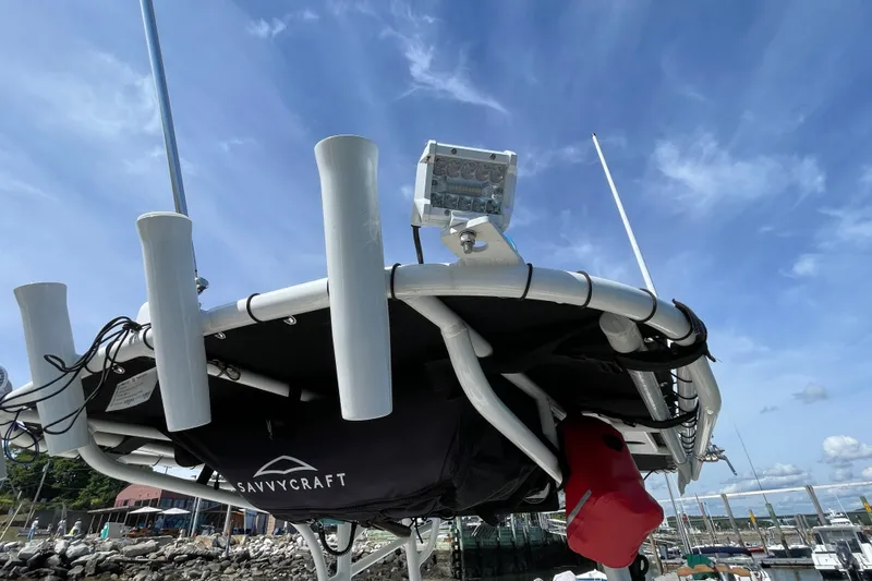 Slide: The Image of 2023 Mako 214 Center Console boat with rod holders and equipment, docked under a clear sky. - 43