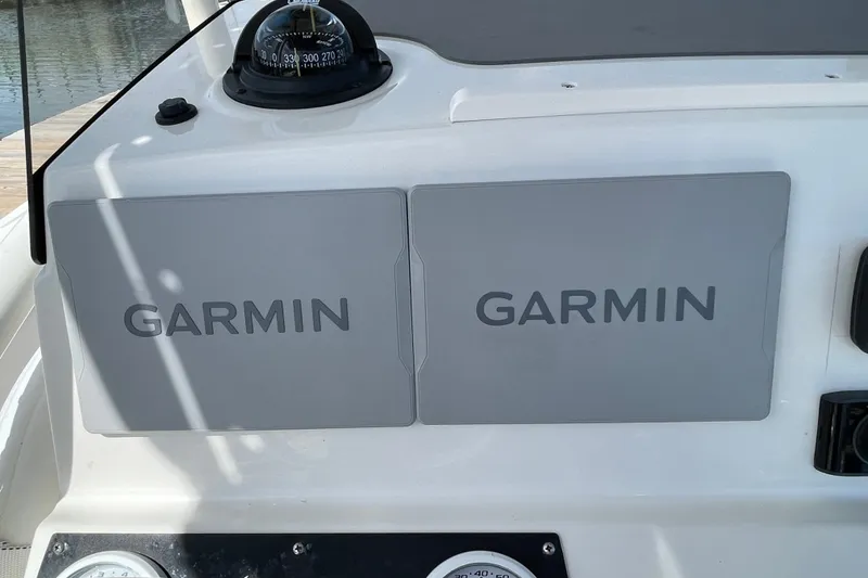 Slide: The Image of 2023 Mako 214 Center Console dashboard with Garmin navigation displays and compass. - 28