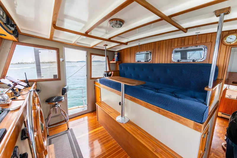 Slide: The Image of Interior of a 1991 Kadey-Krogen 42 boat with blue seating and wooden accents. - 4