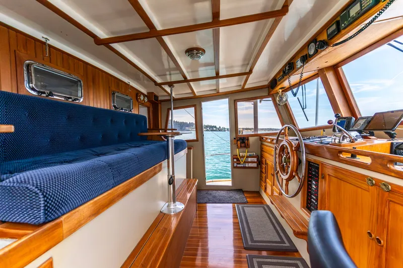 Slide: The Image of Interior of a 1991 Kadey-Krogen 42 yacht with wooden finishes and blue seating. - 2
