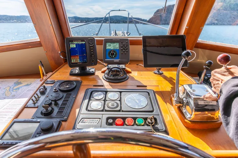Slide: The Image of Helm of 1991 Kadey-Krogen 42 yacht with navigation instruments and controls, overlooking scenic waters. - 3